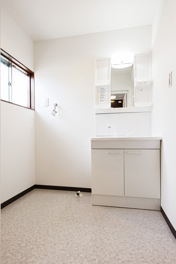 古くなり汚れていた洗面室は、約1畳分スペースを拡張しました。白を基調とした清潔感ある空間になりました。
