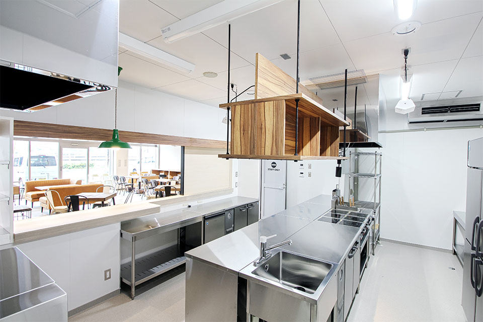 厨房内の無機質な素材感の中に創作家具が温かみと収納スペース（機能性）をもたらしています。