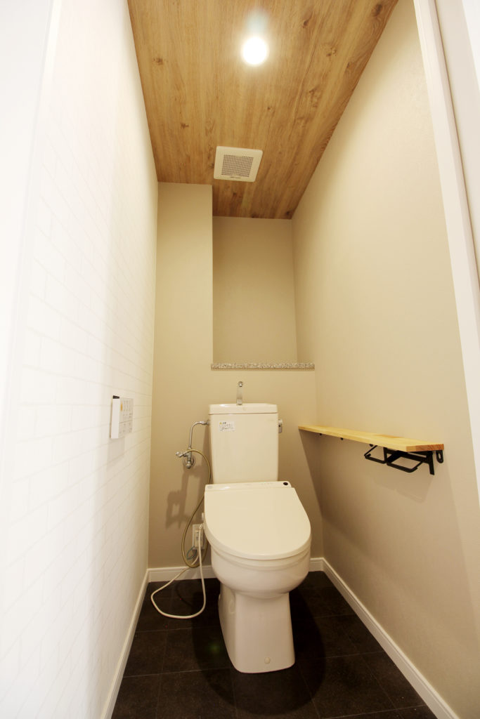 トイレは壁紙と床材を貼り替えました。天井は木目調、壁は少し赤みのある石目柄を選びました。