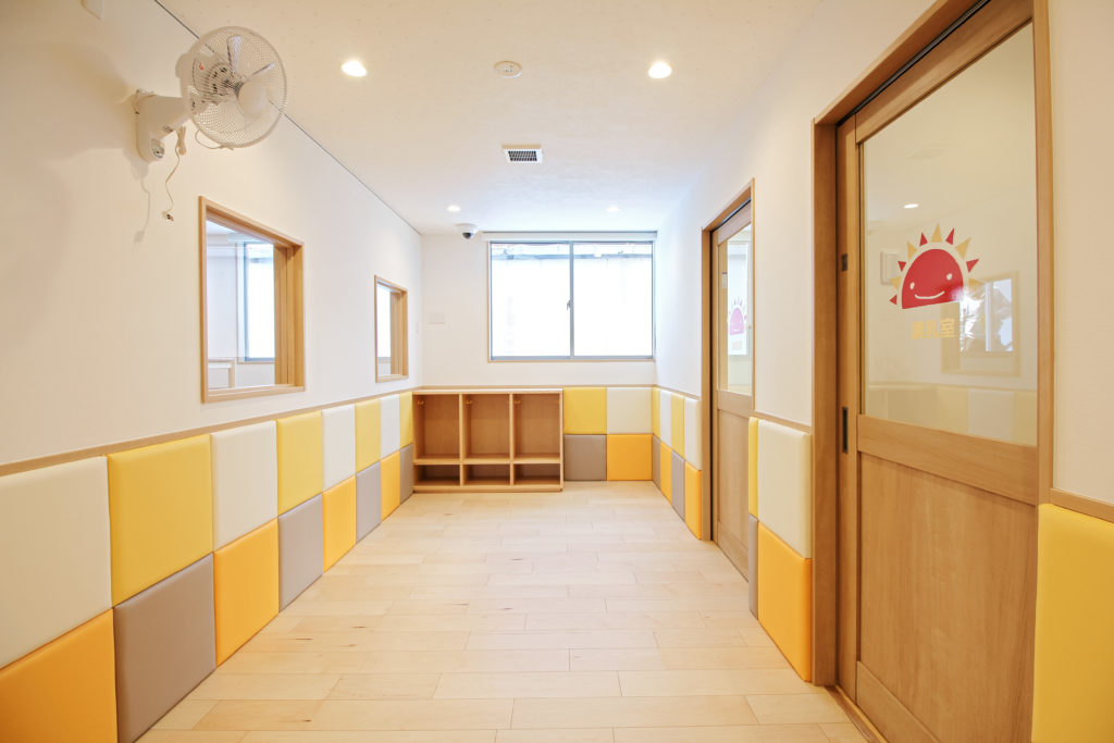 保育室の腰壁には、部屋ごとにカラーリングを変えたクッション材を張り、 園児にも優しく明るい雰囲気です。