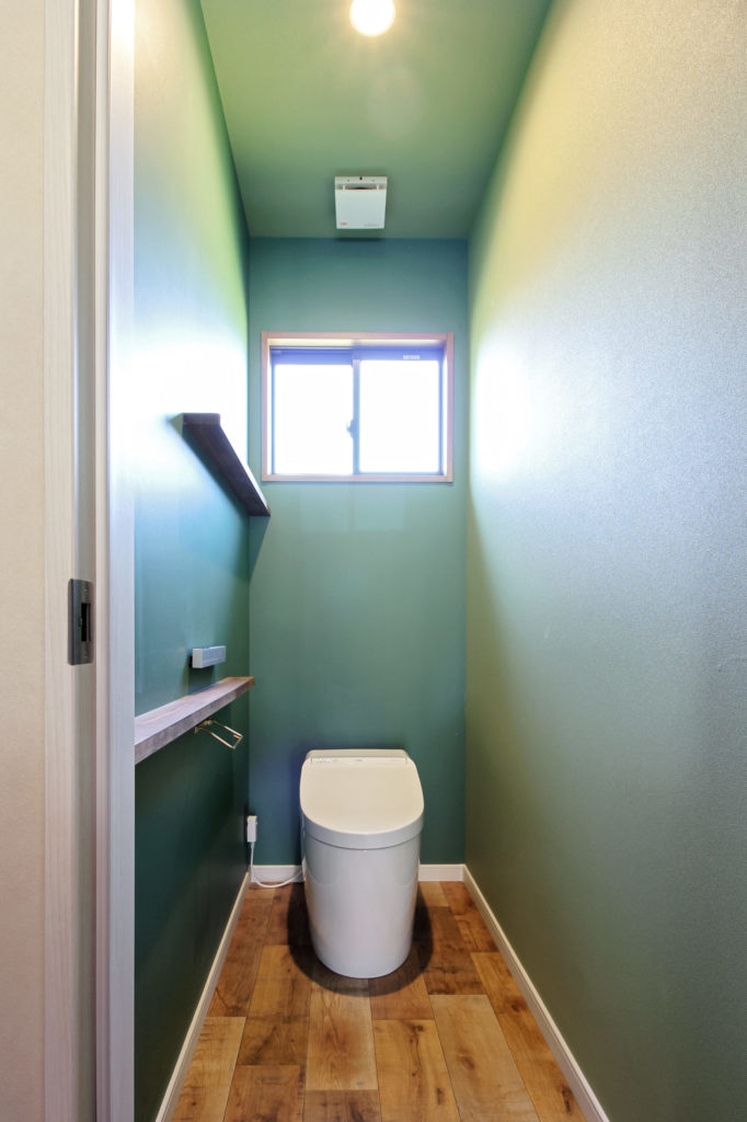 トイレはライムグリーンとモスグリーンの壁紙を張り分け、異国情緒のある空間に。カウンターは手摺としても使えるように補強を入れ、設置高さにもこだわりました。