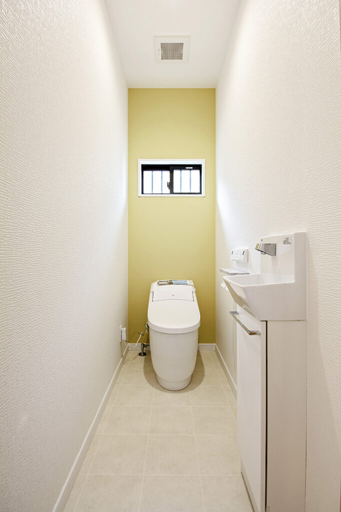 トイレはコンパクトなフォルムが特徴的なプレアスLSを使用。撥水加工付きのイエロー壁紙でアクセントを加えました。