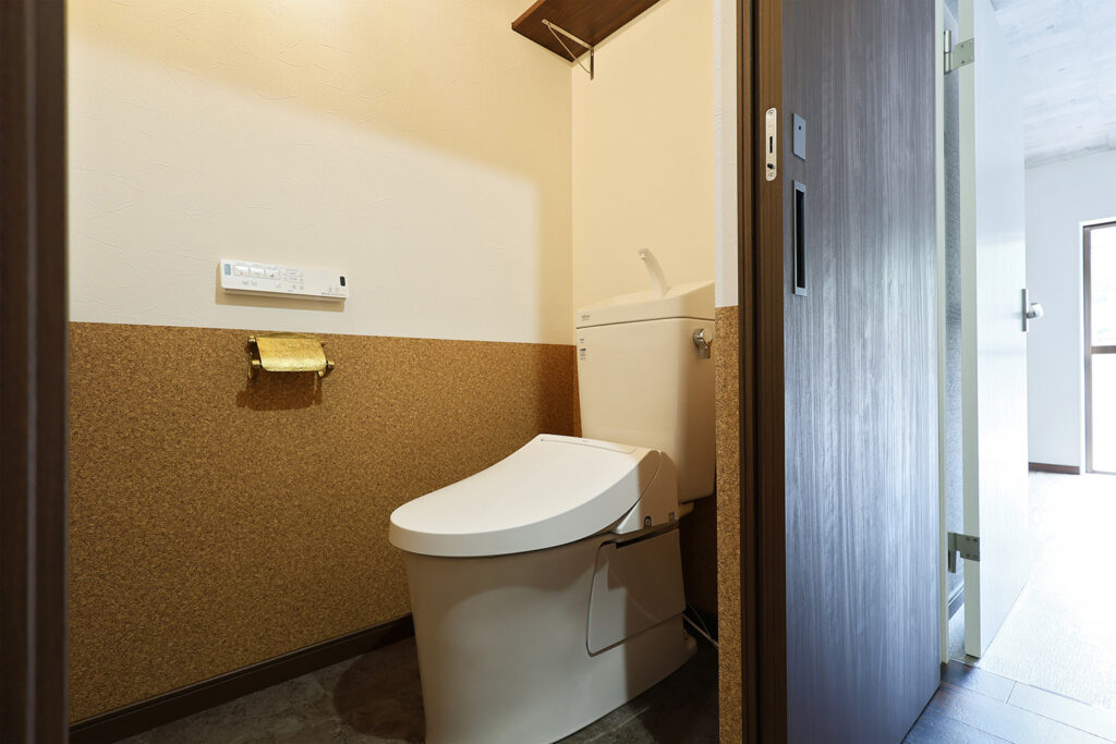トイレは扉を引戸に変えて、より使いやすく。壁紙にはコルク柄を腰壁として採用しました。