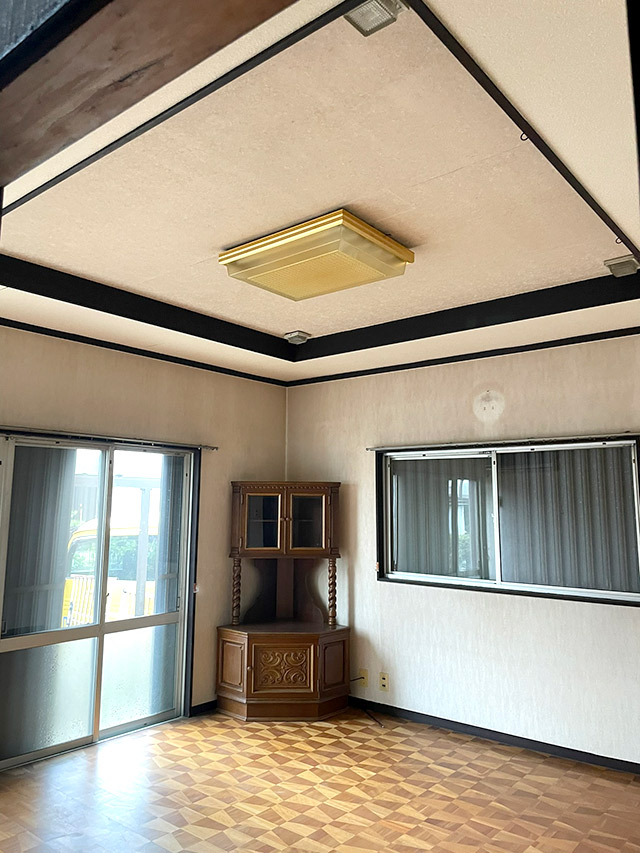 リノベーション前の居室の様子。木製の床と天井照明、古い収納家具が残る状態を記録した室内写真