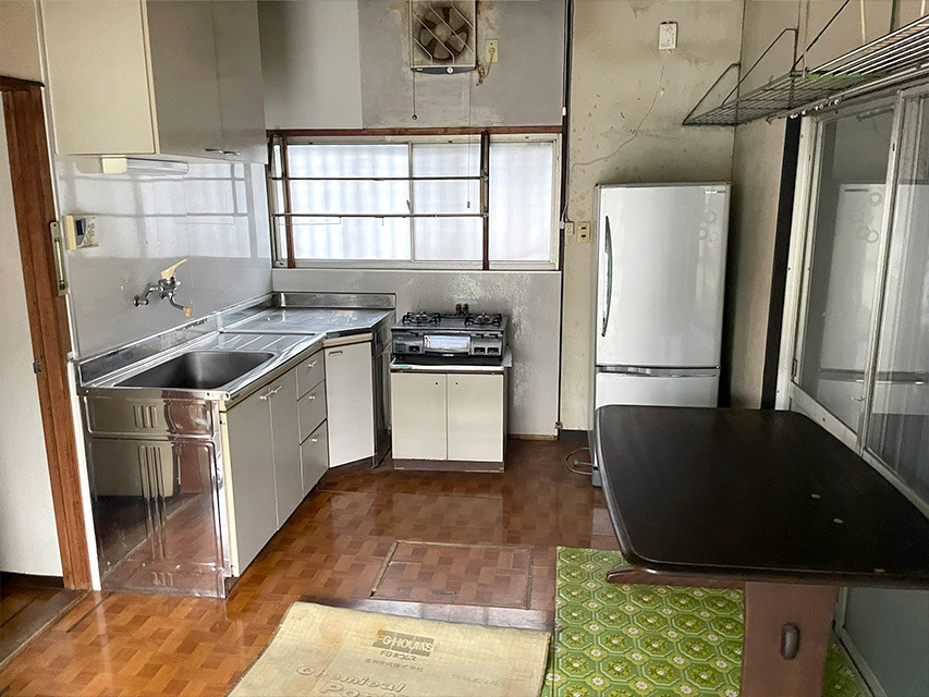 リノベーション前のキッチンの様子。昔ながらの流し台やガスコンロ、冷蔵庫が残る状態を記録した写真