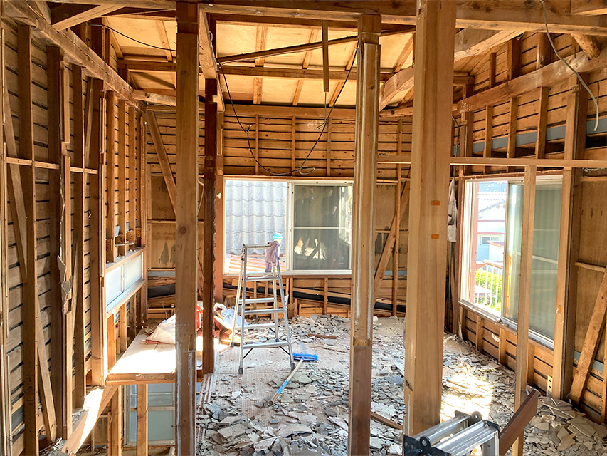 住宅の内装を解体し、壁や天井の下地が露出した室内の様子を撮影した写真。