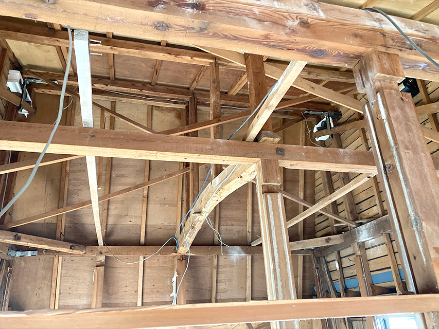 天井の下地や梁がすべて露出し、構造材の状態が確認できる室内の解体後の様子を写した写真。