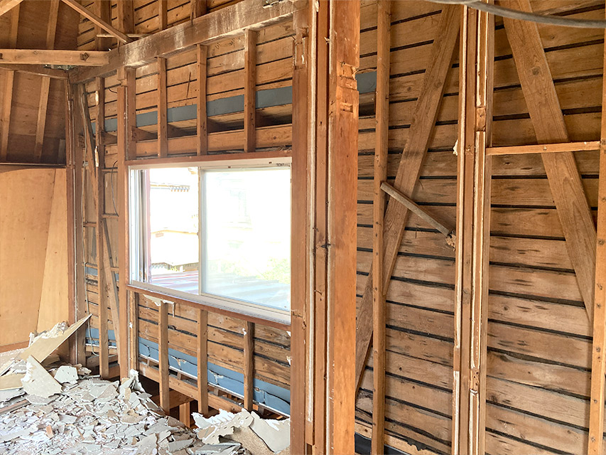 室内の壁を解体し、木材の下地や筋交いが見えている状態を写した写真。