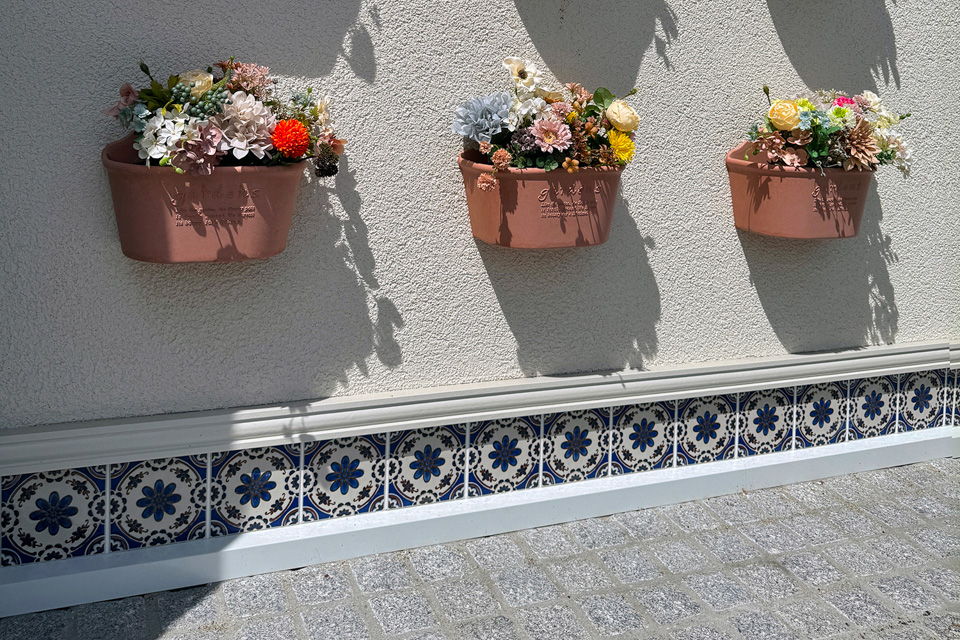 ヨーロッパの伝統柄の装飾タイルとテラコッタ調の壁掛プランターをアクセントに。