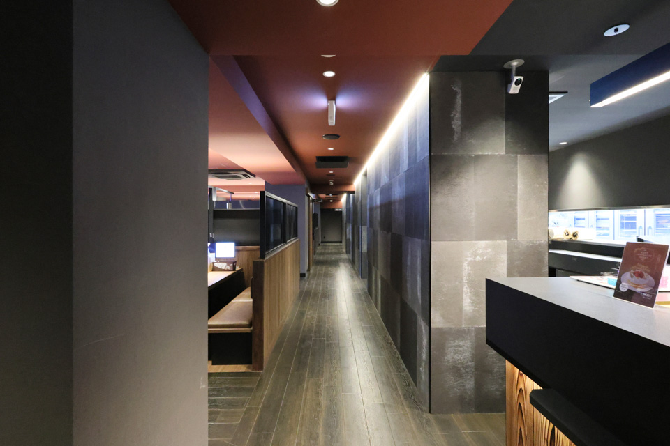 客席とパントリーとの境の壁は石目のサイディング張りで重厚感を、LED間接照明で軟らかさ、明るさを演出しています。