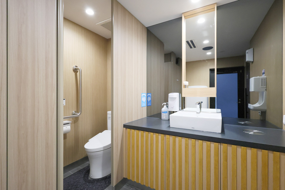 トイレ：木目基調は変わりませんが清潔感を重視した色合いとブラックミラーで空間も広く感じます。 女性用化粧室にはベビーシートが設置され乳児にも優しい設備を整えております。