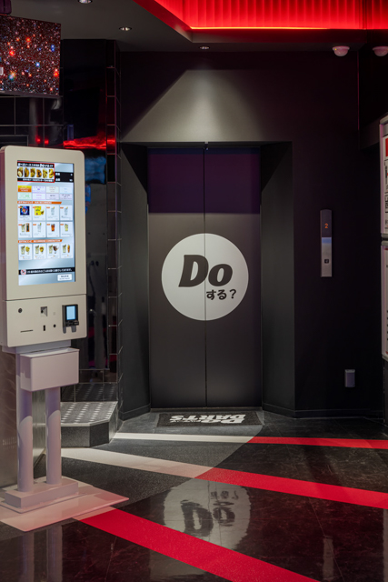 入ってくるときは圧巻！帰りのエレベーターの「Doする？」サインはシンプルながら、関西っぽいユニークさがうかがえるデザインで、思わずダーツ台に戻ってしまいそうです。