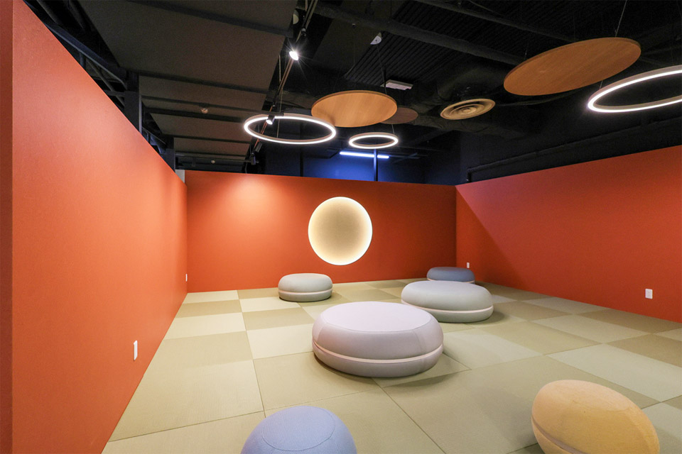 思わず寝てしまうような空間を提供したく、意図的に照度を落としました。朱色の壁に柔らかな円形照明を設けて趣がある和空間を表現しました。